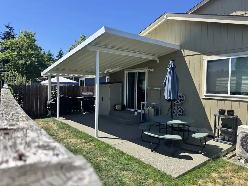 White cover over a patio with an umbrella and table