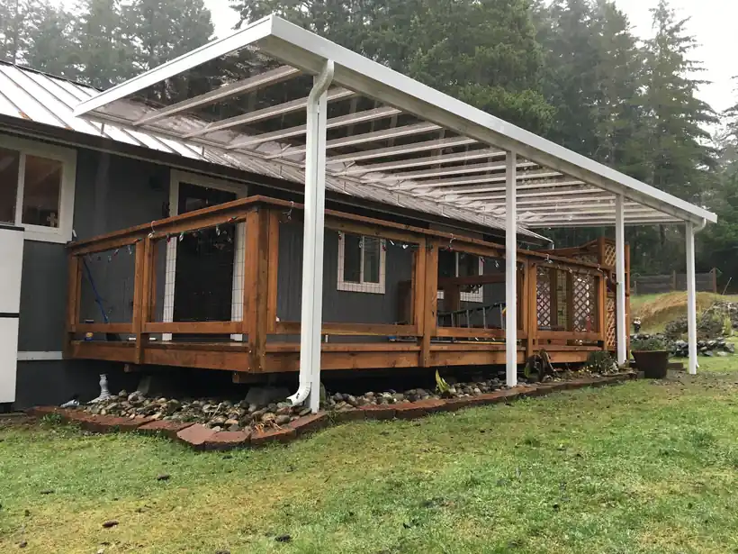 White patio cover over a cedar deck with a railing