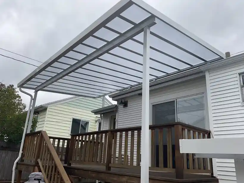 White polycarbonate cover over a deck with wood rails