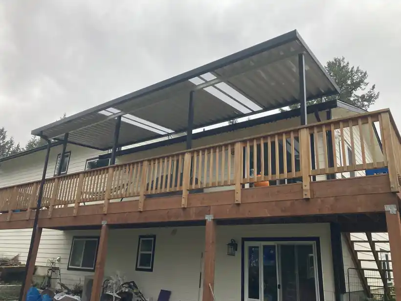 Dark patio cover over an upper deck with timber rails